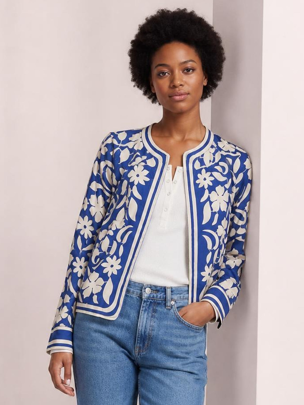 Model wears a blue and white flower print open-front jacket with a rounded neckline, long sleeves, striped cuffs, and a relaxed silhouette.