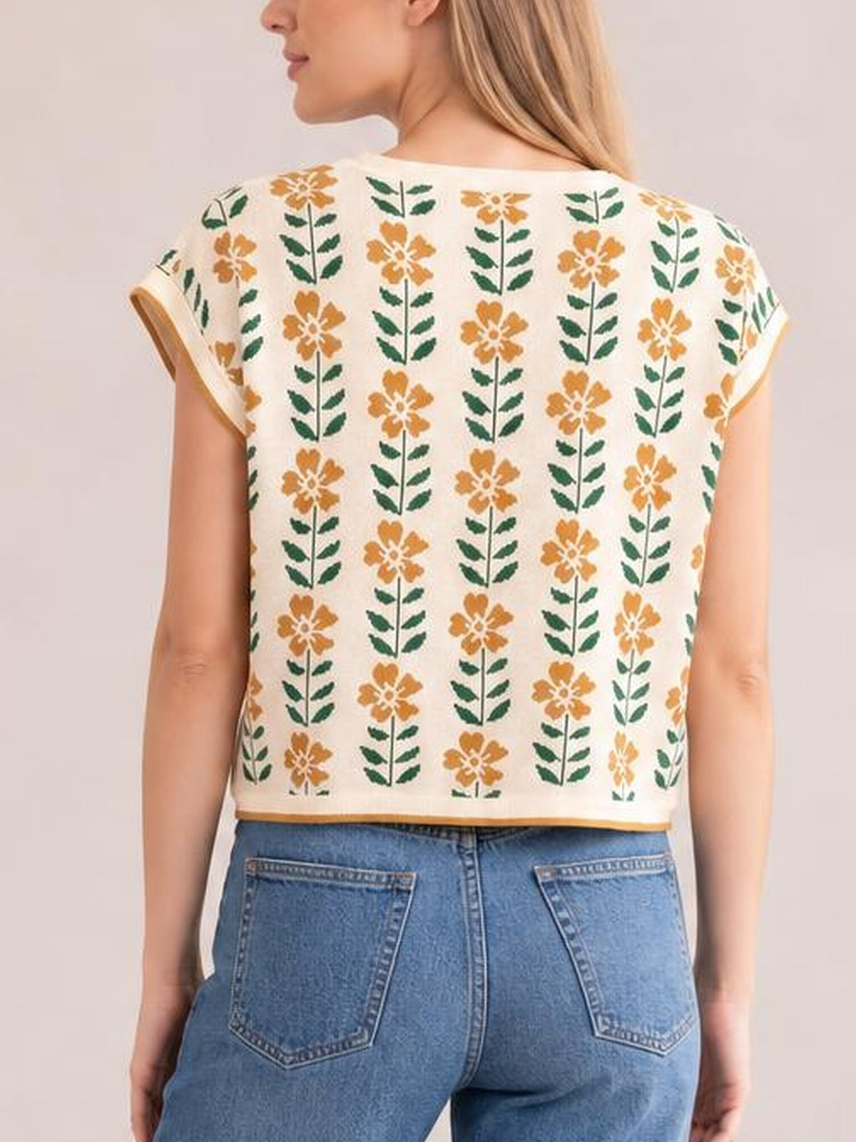 Back view of a cream Flower Round Neck Short Sleeve Knit Top with orange and green floral rows, a relaxed straight silhouette, and a waist-length hem.
