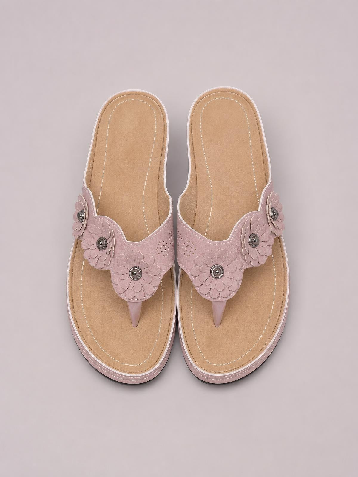 Pink PU leather flower toe post sandals feature layered floral straps, stitched cushioned footbeds, and low rubber soles.