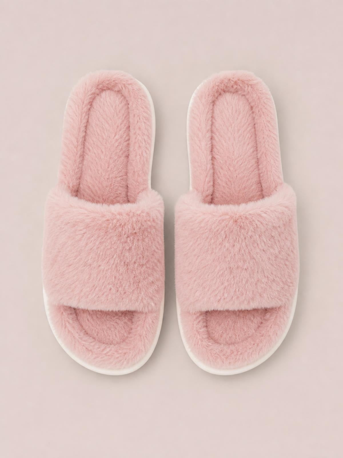 Pair of pink fluffy open toe comfort slippers with wide plush straps, cushioned interiors, rounded fronts, and flat white soles.