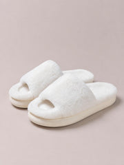 White fluffy open toe comfort slippers feature wide plush uppers and thick flat rubber and PVC soles, shown as an overlapping pair.