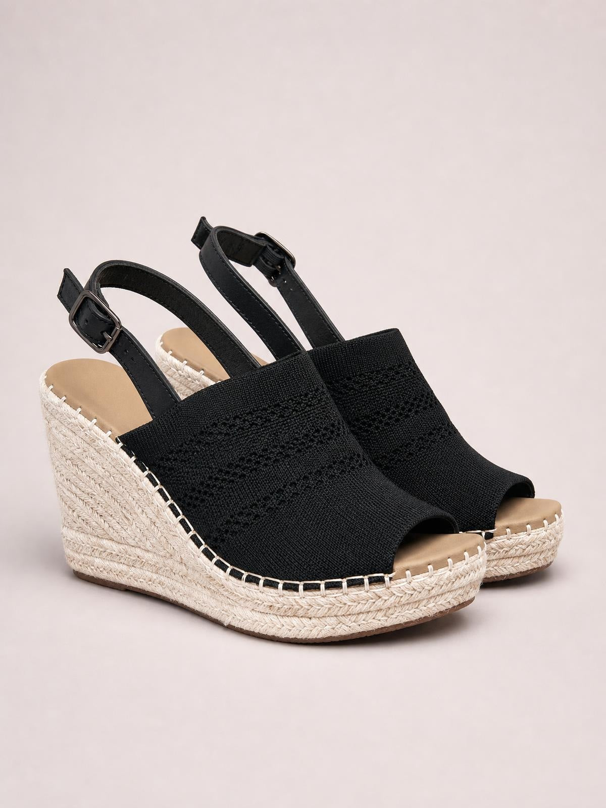 Black peep-toe high heel sandals with textured woven uppers, adjustable ankle straps, and tall espadrille wedge heels in a platform silhouette.
