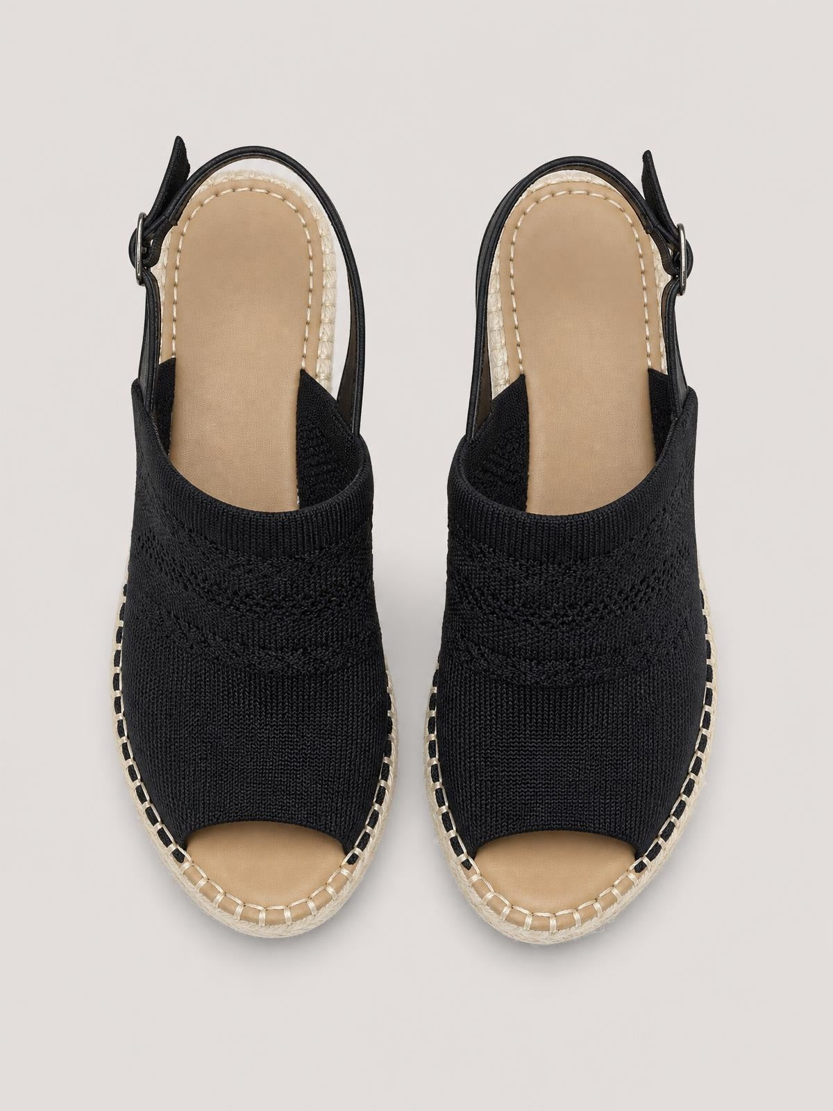 Black peep-toe sandals feature textured woven uppers, tan footbeds, braided espadrille-style soles, and adjustable ankle straps with buckles.