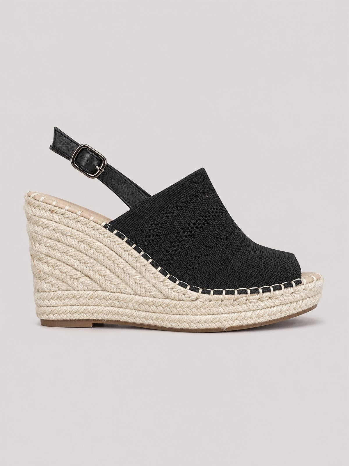 Black high-heel sandals feature a textured upper, adjustable ankle buckle, and a tall woven espadrille wedge platform with a gently rounded toe.