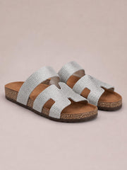 Silver rhinestone open toe sandals with wide decorative straps, cushioned footbeds, and flat textured soles.