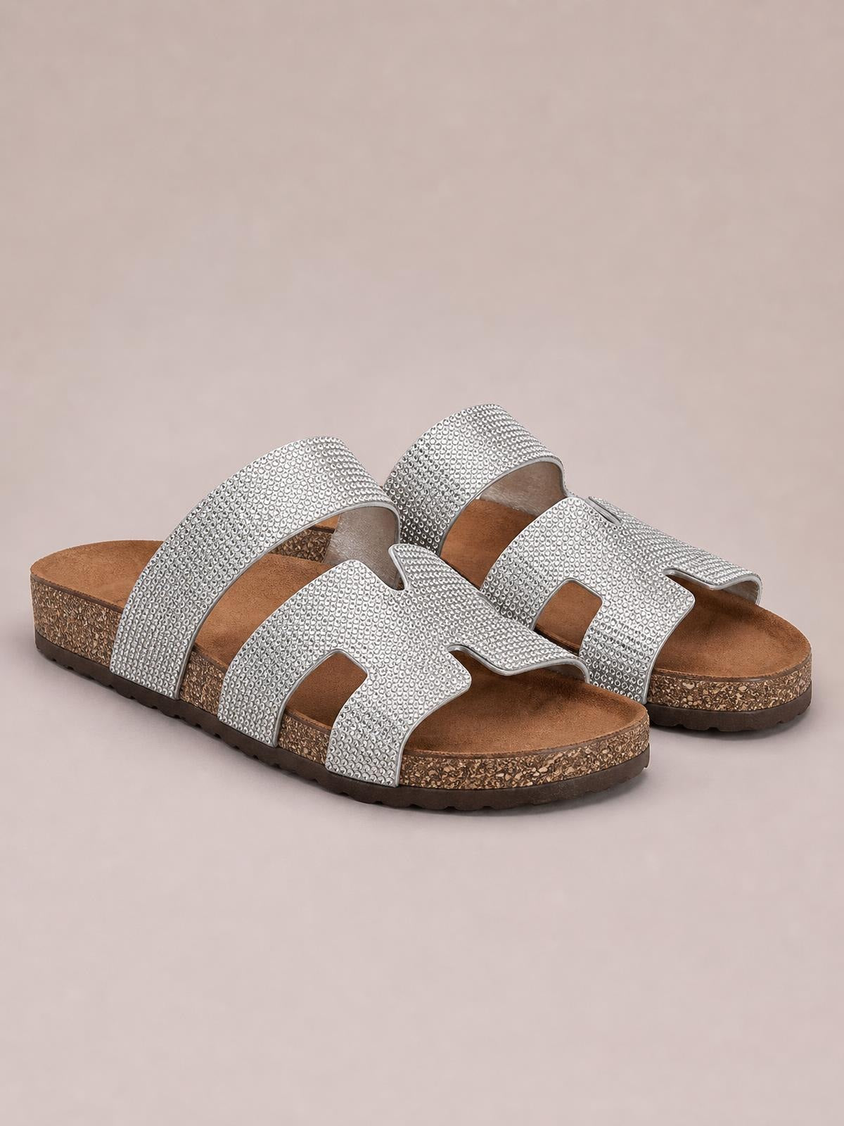 Silver rhinestone open toe sandals with wide decorative straps, cushioned footbeds, and flat textured soles.