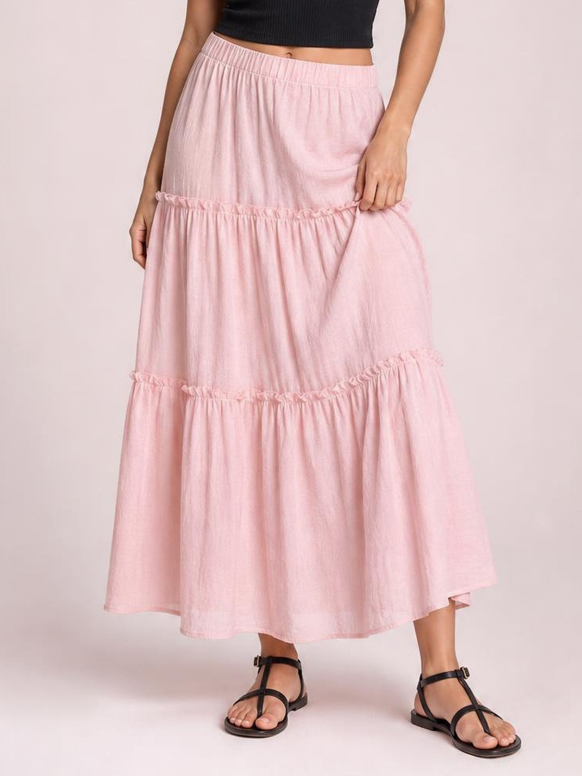 Model wearing a light pink Frill Elastic Waist Skirt with a tiered midi silhouette, gathered frill details, and a comfortable elastic waistband.