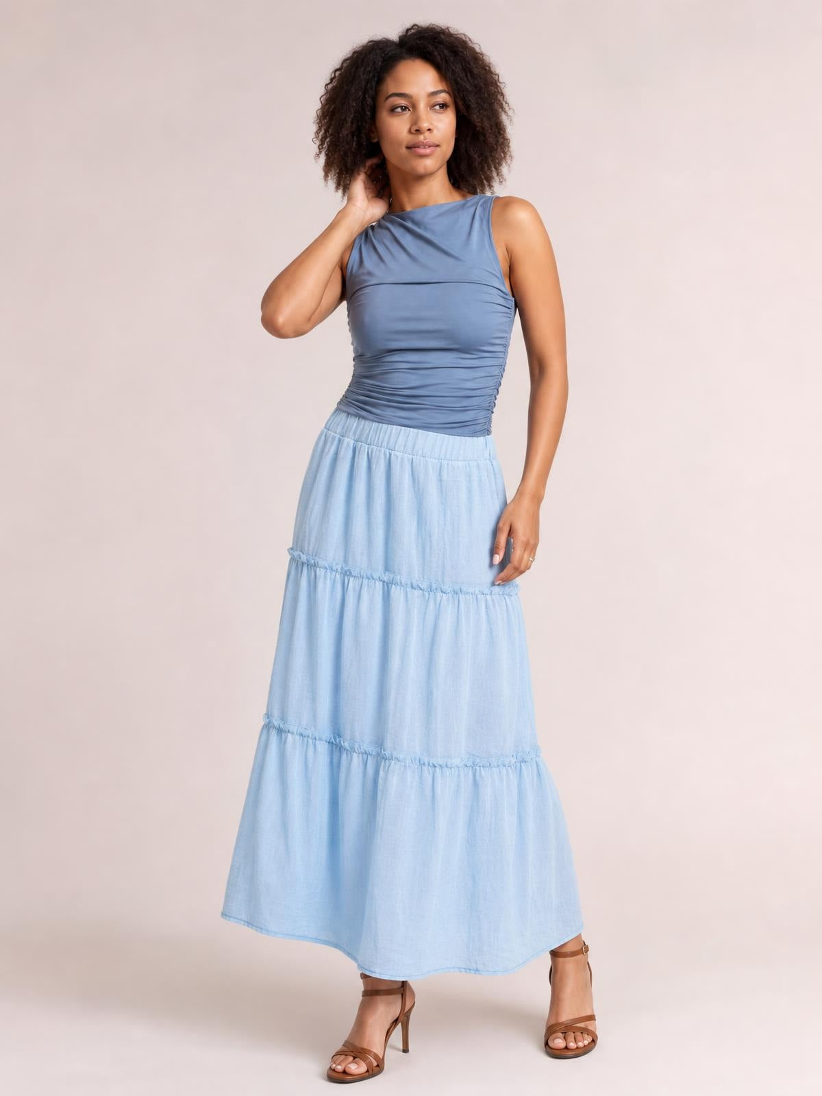 Model poses in a light blue Frill Elastic Waist Skirt with a comfortable gathered waistband, tiered frill detailing, and a flowing maxi silhouette.