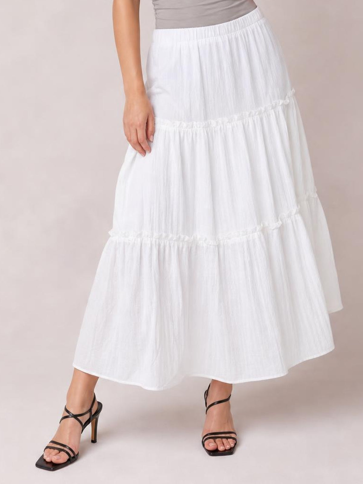 Model wears a white Frill Elastic Waist Skirt with a flowing midi silhouette, gathered tiers, delicate frill trim, and a comfortable lined construction.