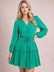 Model poses in a turquoise frill V-neck mini dress with long gathered sleeves, button-front construction, adjustable waist tie, and flowing tiered skirt.