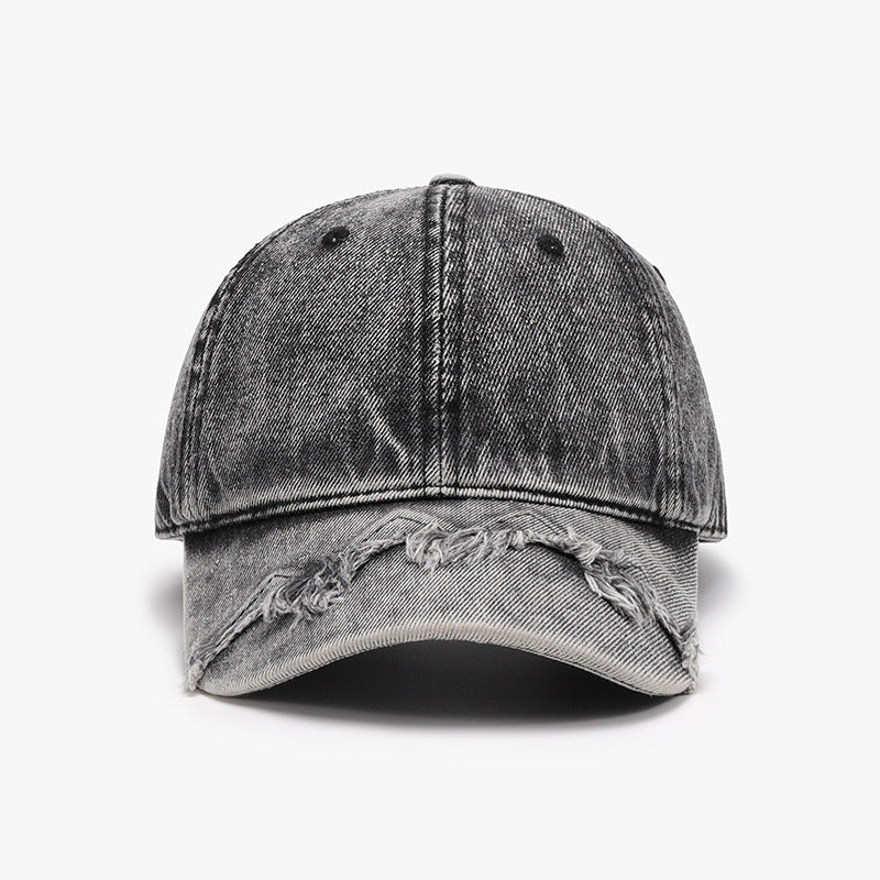 Gray cotton baseball cap with a classic six-panel silhouette, curved brim, visible seam construction, and distressed fringe detailing along the front edge.