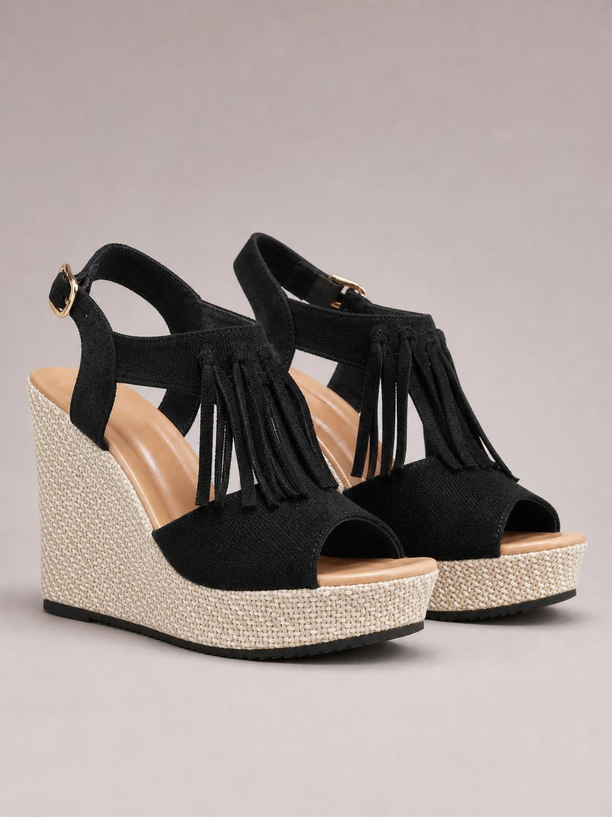 Black fringe peep toe wedge sandals with ankle buckle straps, textured uppers, woven espadrille-style mid heels, and rubber outsoles.
