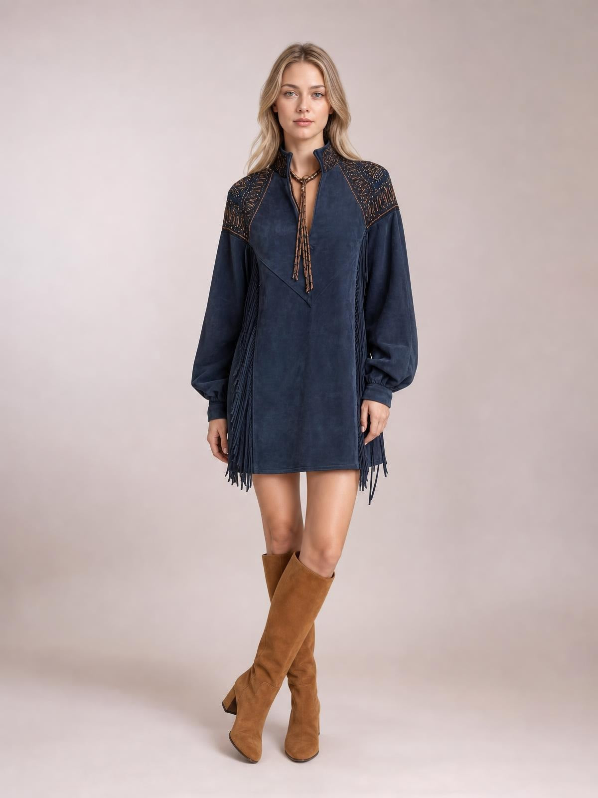 Model poses in a navy mini dress with lantern sleeves, zip front, shoulder detailing, and long side fringe creating a straight silhouette.
