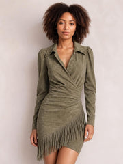 A model poses front-facing in an olive green fringed long sleeve mini dress with a collared wrap bodice, ruched waist, and asymmetrical fringe hem.