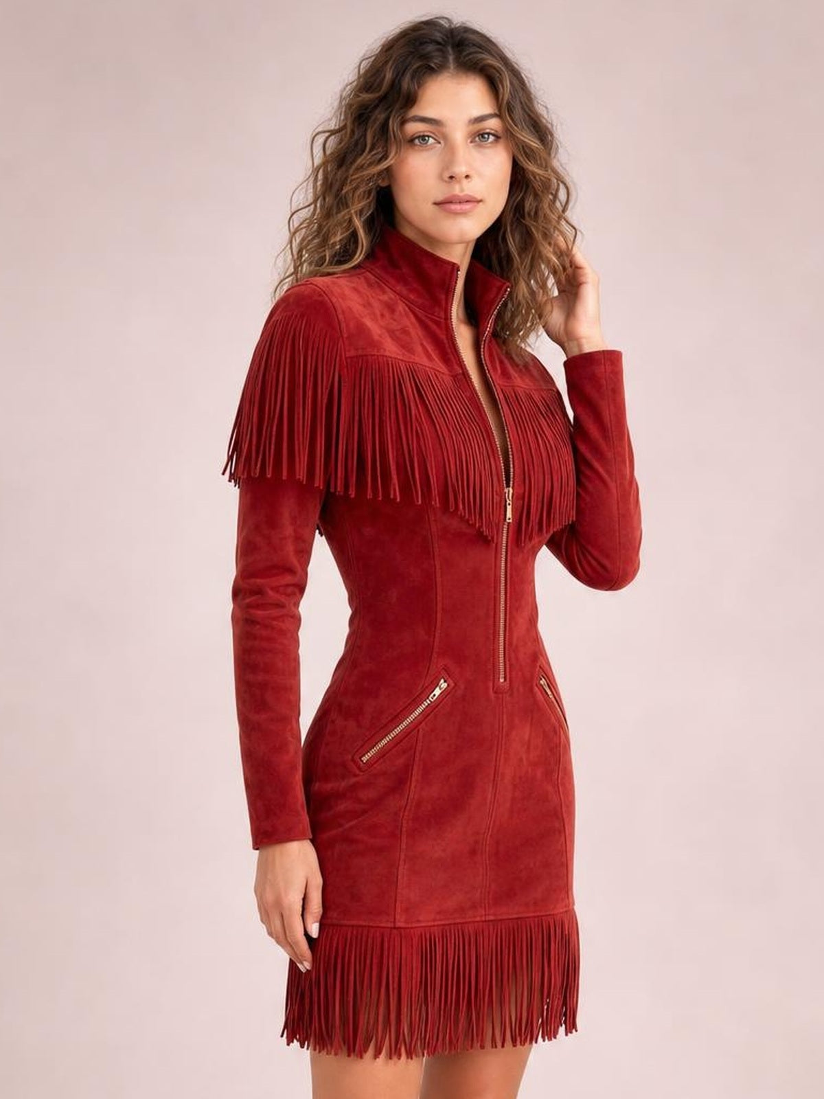 A model poses in a fitted red zip-front mini dress with long sleeves, a stand collar, zippered pockets, and dramatic fringe across the shoulders and hem.