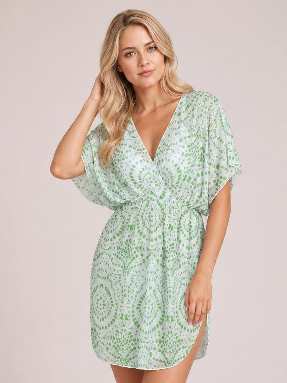 Model poses in a mint green and white boho print surplice beach cover-up dress with flowing kimono sleeves, a gathered waist, and side slit.
