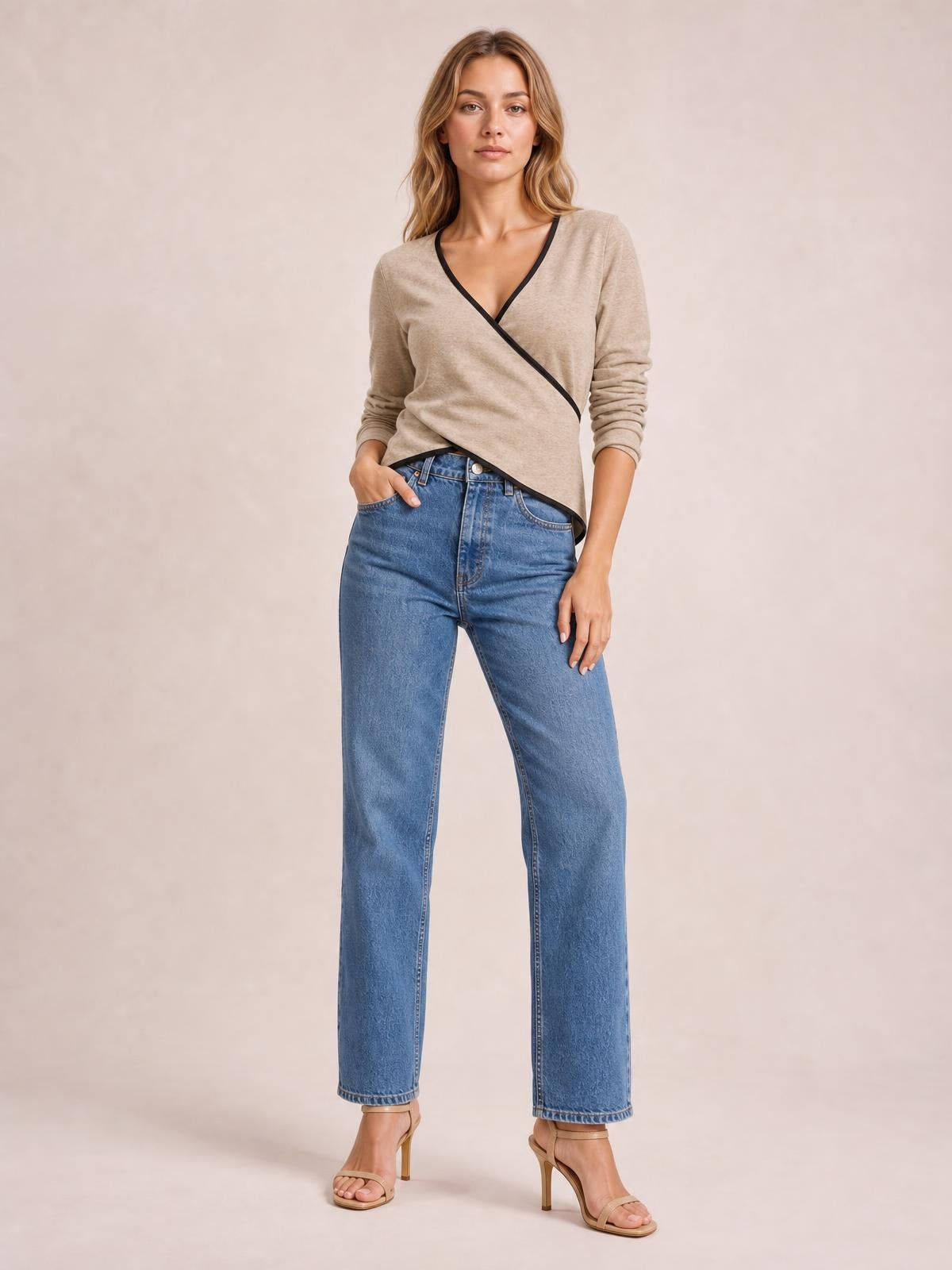 Model wears a taupe long-sleeve T-shirt with black contrast trim and a crisscross wrap-style V-neck, shown in a relaxed standing pose.