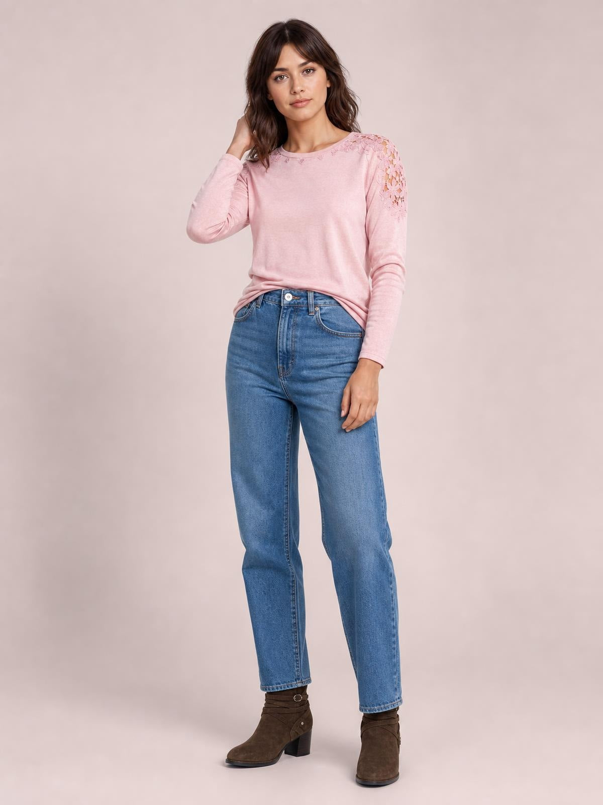 A model poses in a pink cutout round neck long sleeve T-shirt with lace detailing along the shoulder and upper sleeve in a relaxed silhouette.