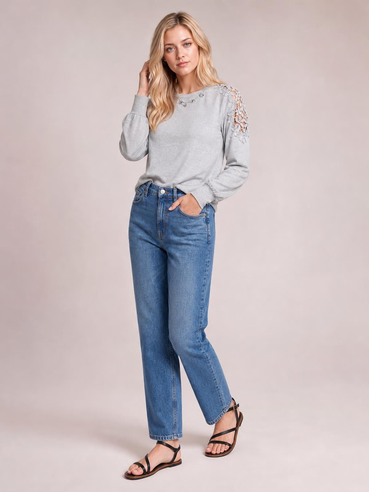 Model poses in a gray cutout round neck long sleeve T-shirt with lace-detail shoulder panels, a relaxed silhouette, and slightly gathered cuffs.