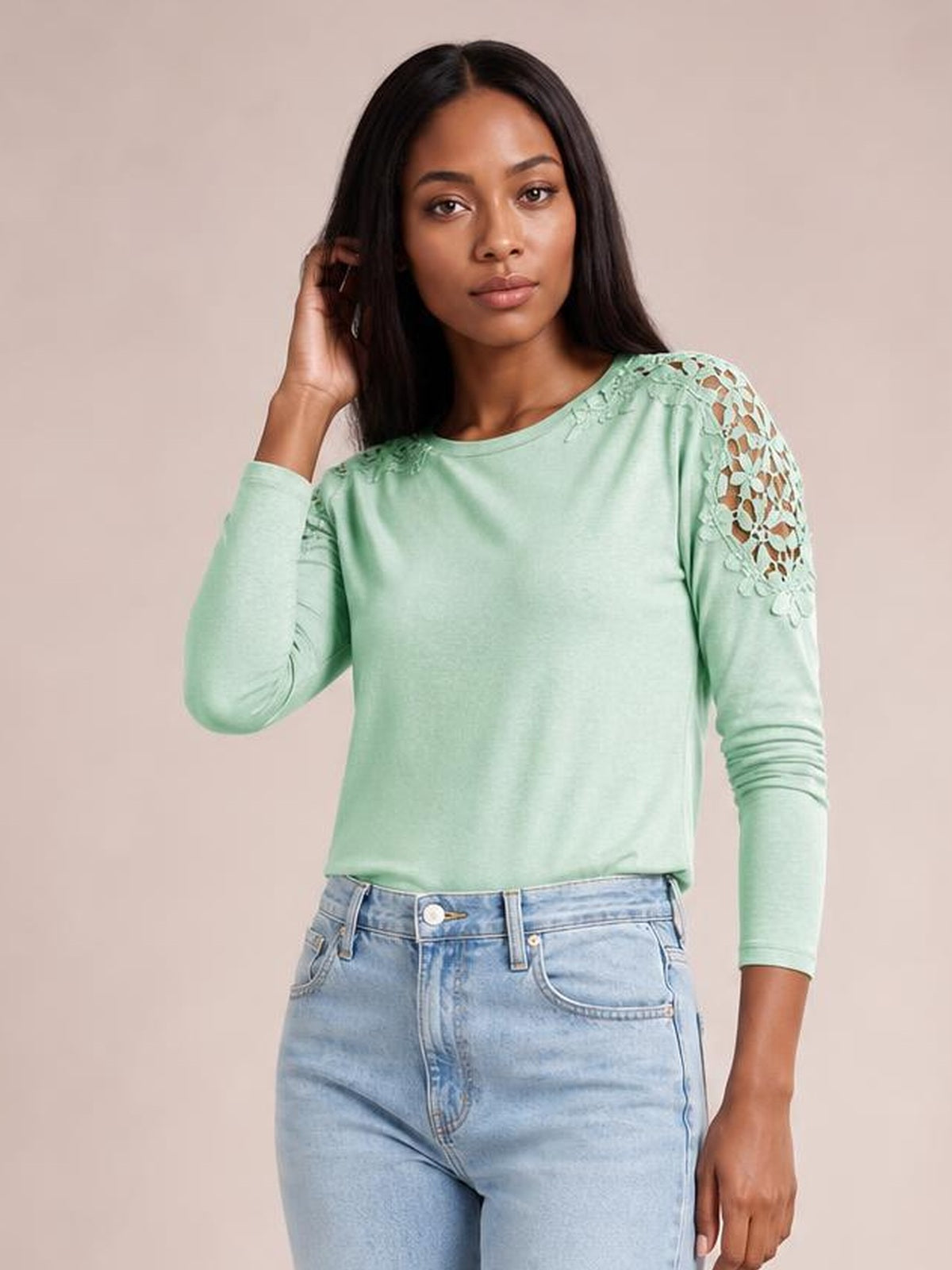 Model poses in a mint green cutout round neck long sleeve T-shirt with semi-sheer lace shoulder and sleeve details and a relaxed silhouette.