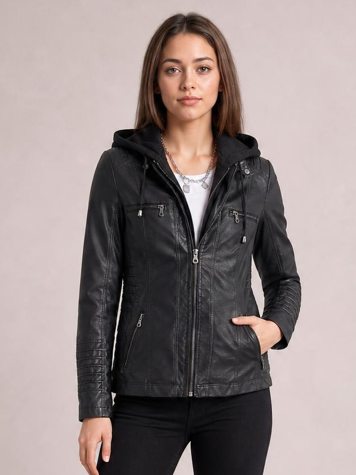 Model wearing a black faux leather moto jacket with a hood, zip closure, seam detailing, multiple zippered pockets, and a regular silhouette.