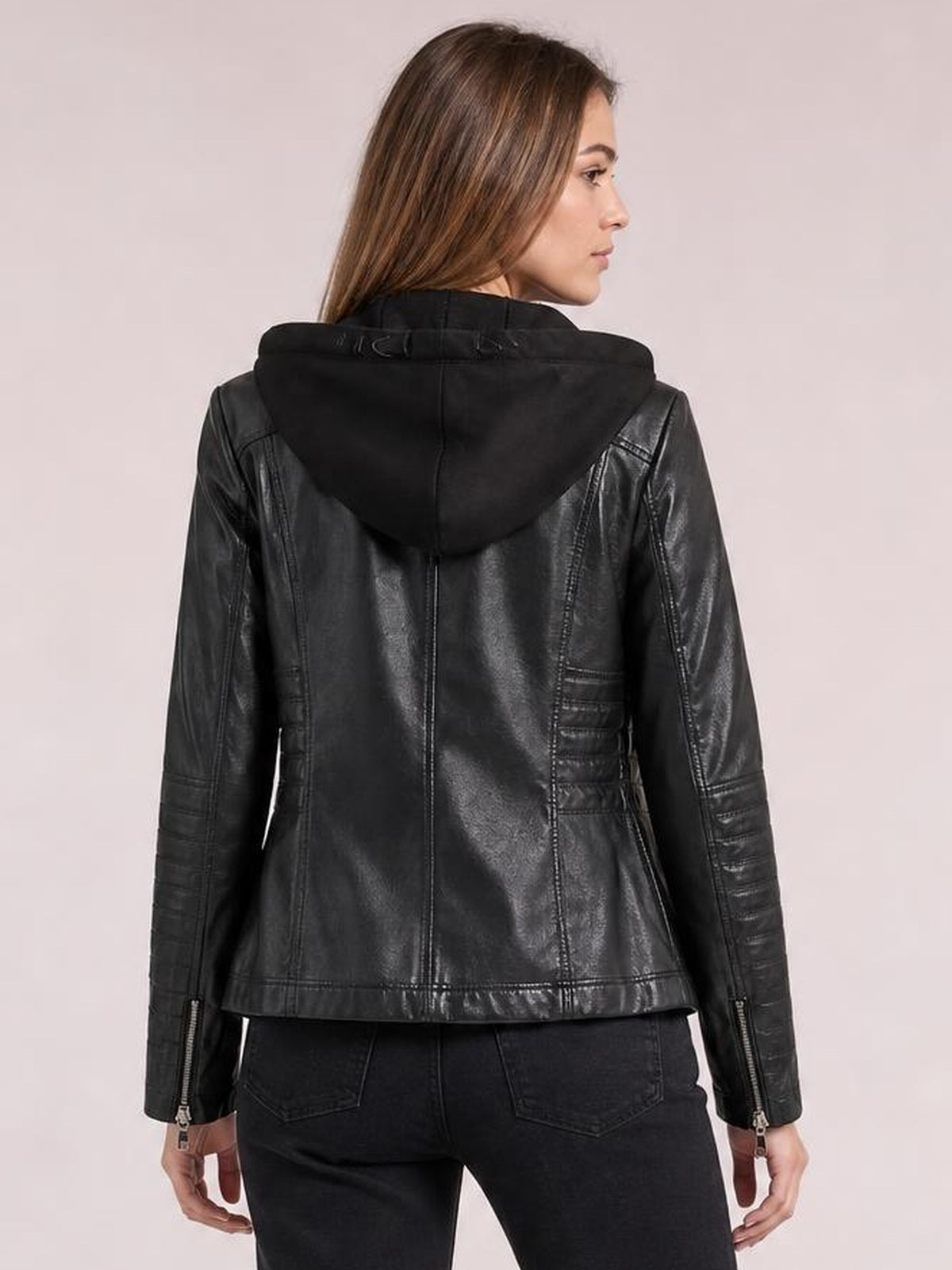 Model shown from the back wears a black faux leather moto jacket with a hood, zippered sleeves, seam detailing, and a regular fit.