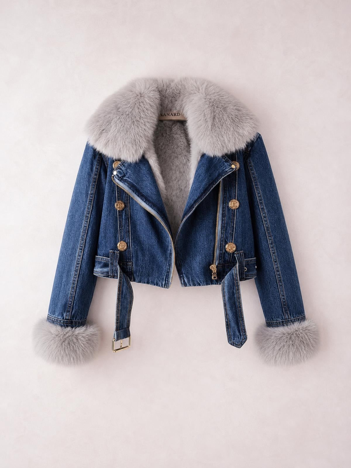 Blue denim jacket with a plush gray faux fur collar and cuffs, cropped silhouette, double-breasted buttons, asymmetrical zipper, and belted waist ties.