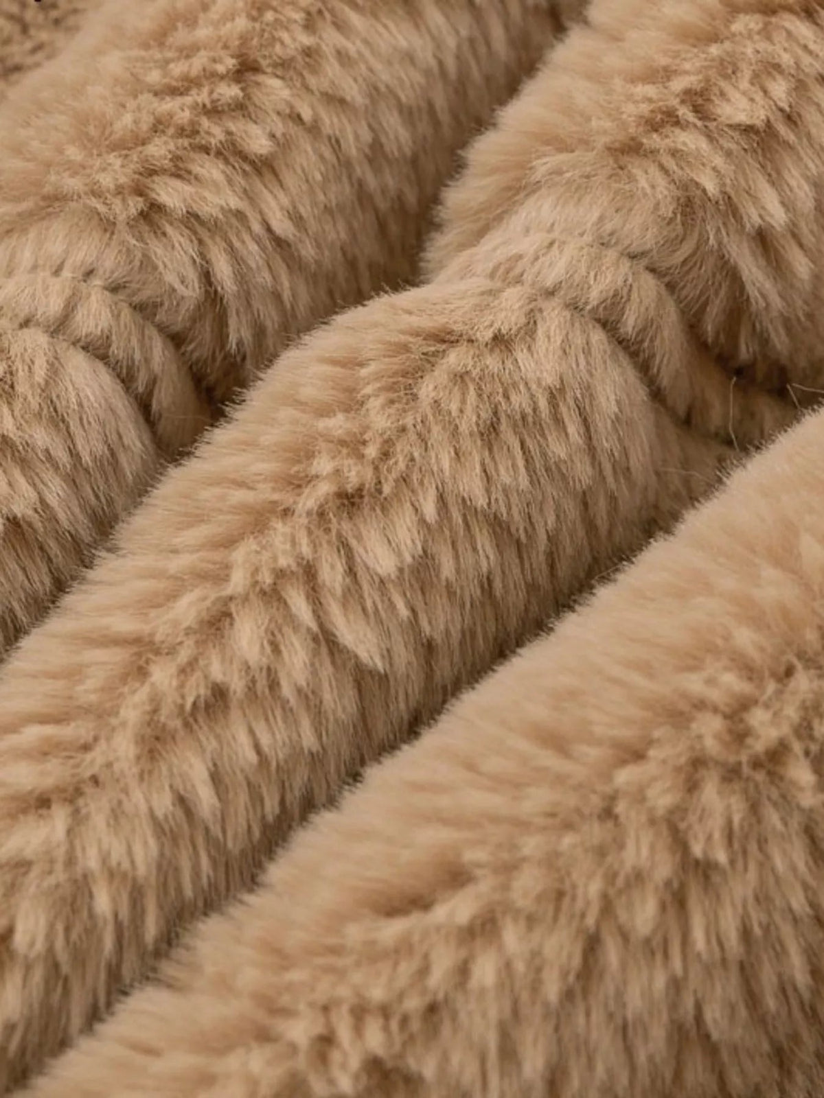 Close-up view of the jacket’s plush tan faux fur texture, showing its thick, soft pile and warm neutral color.