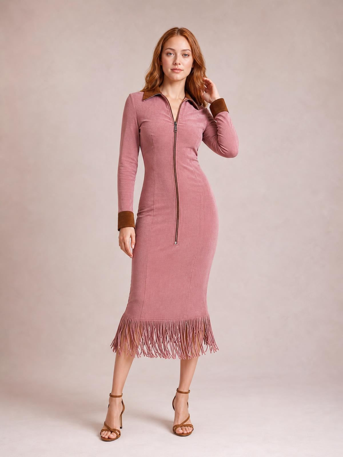 A model poses in a rose-pink fitted midi dress with long sleeves, a zip front, structured collar, and dramatic fringe hem.