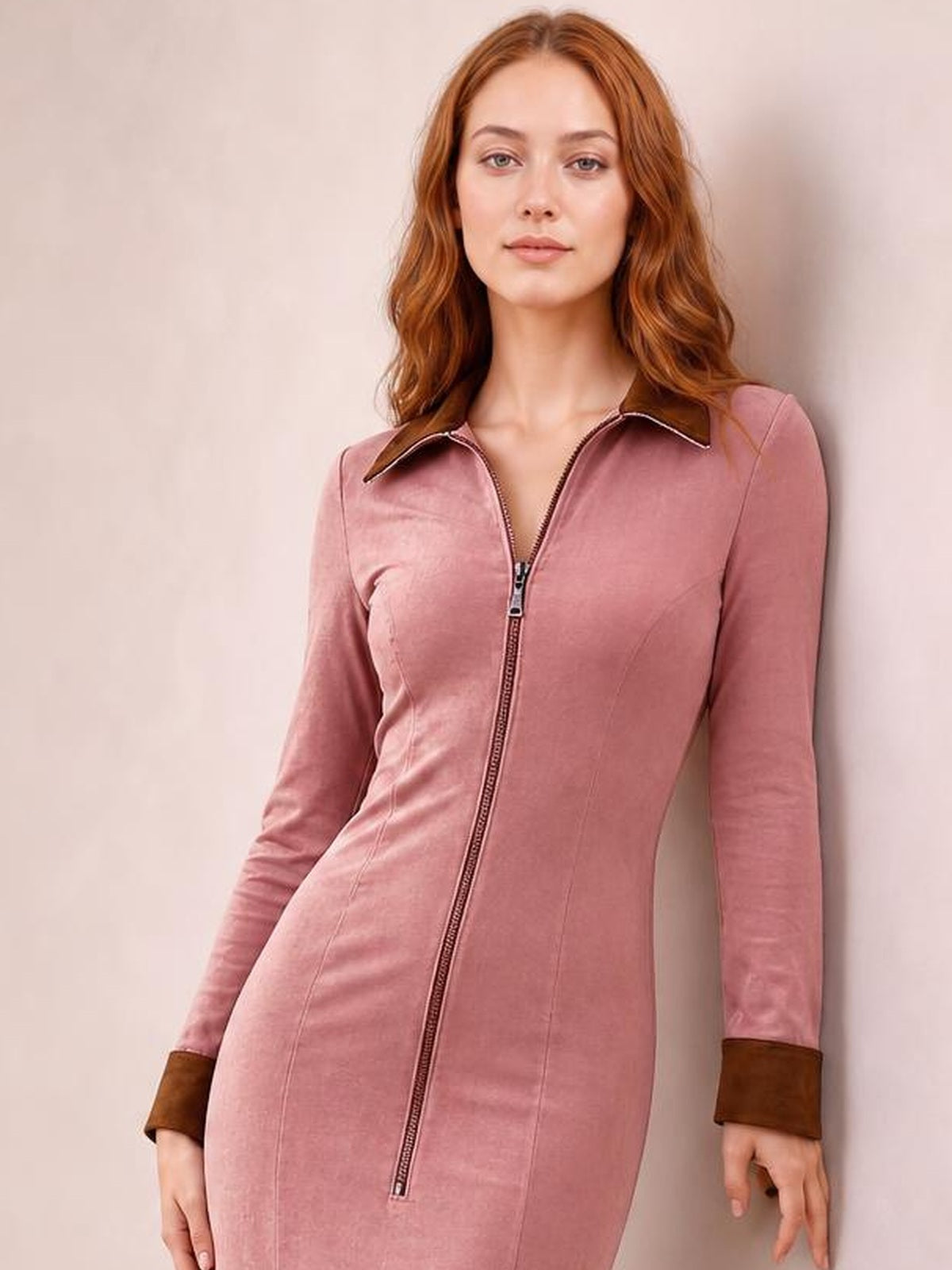 A model wears a dusty rose fitted midi dress with long sleeves, a pointed collar, contrast cuffs, and a full-length center-front zipper.