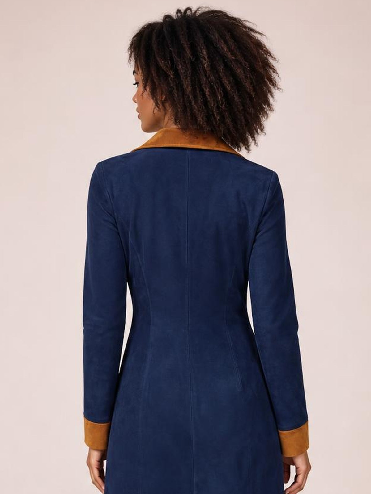 Model shown from behind in a navy long-sleeve midi dress with a fitted silhouette, visible center-back seam, and contrasting tan collar and cuffs.