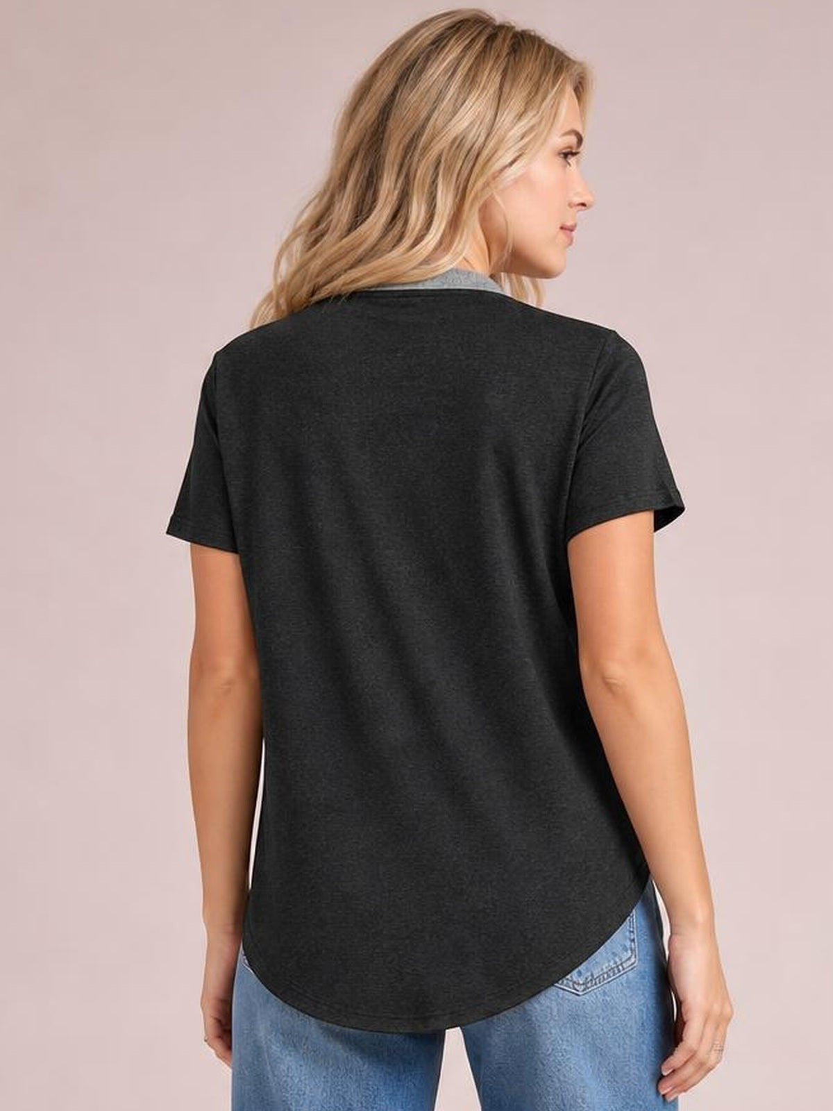 Model shown from the back in a black short sleeve T-shirt with a relaxed silhouette, smooth construction, and rounded shirttail hem.