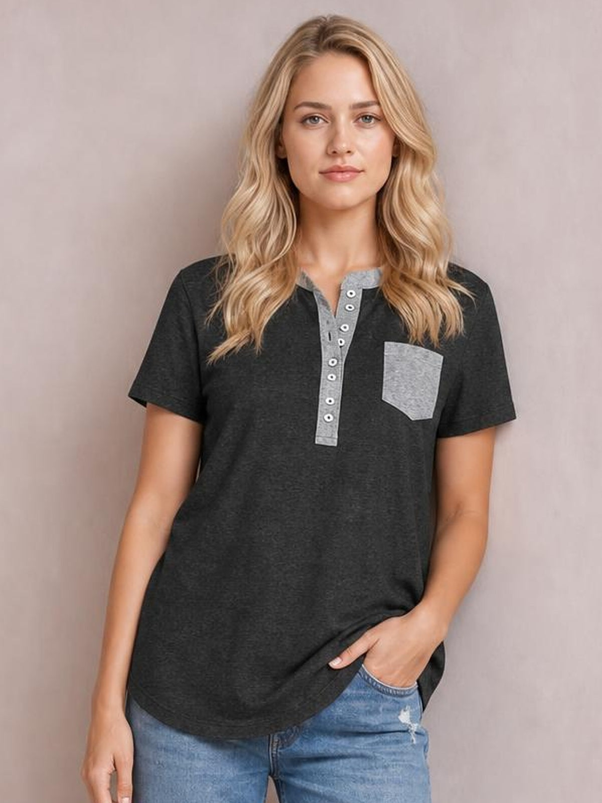 Model poses in a dark gray half-button short sleeve T-shirt with a contrasting gray placket and chest pocket, relaxed straight silhouette, paired with jeans.