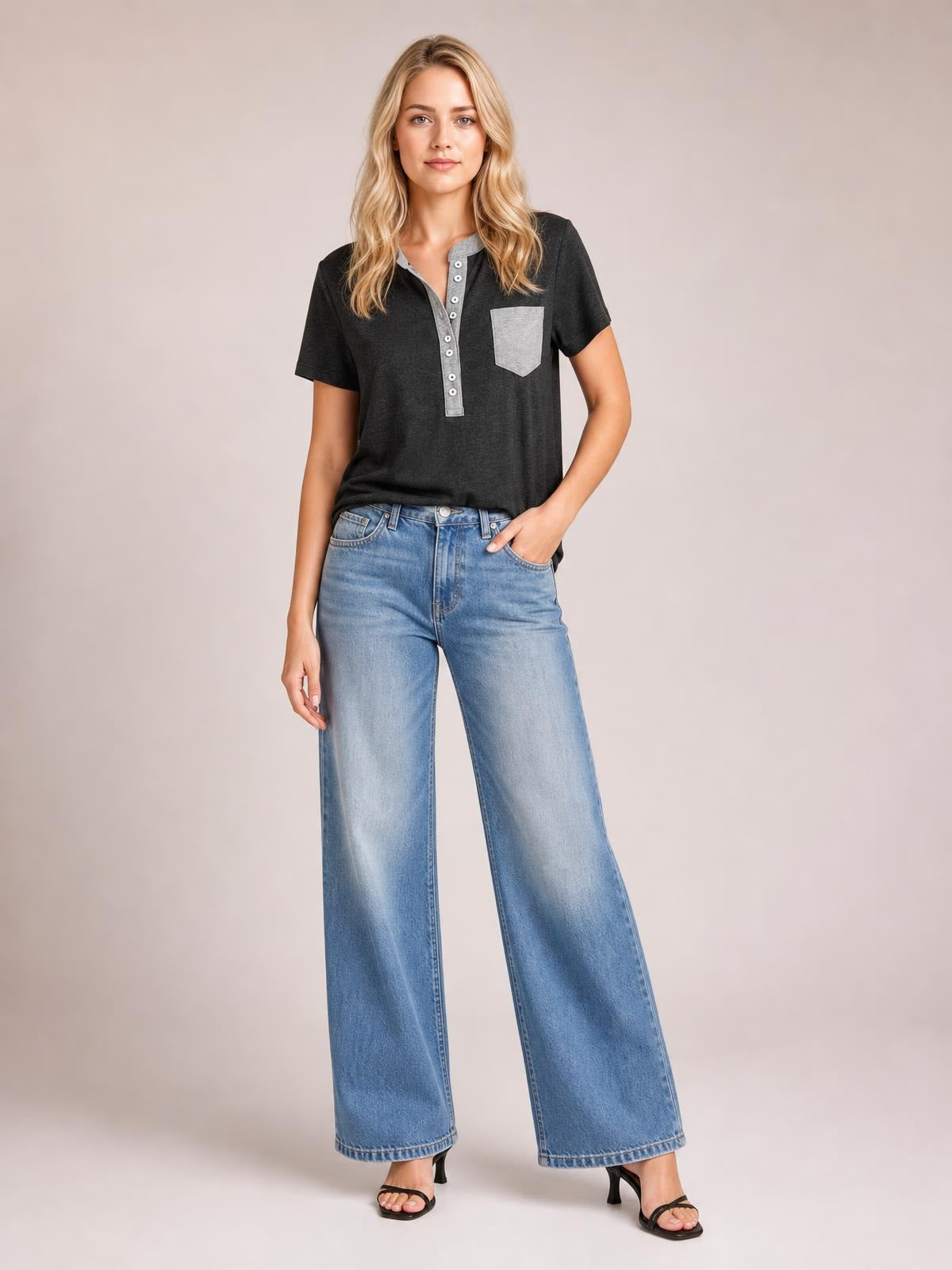 A model poses in a charcoal short-sleeve T-shirt with a half-button placket, contrasting chest pocket, relaxed silhouette, and slightly stretchy opaque fabric.
