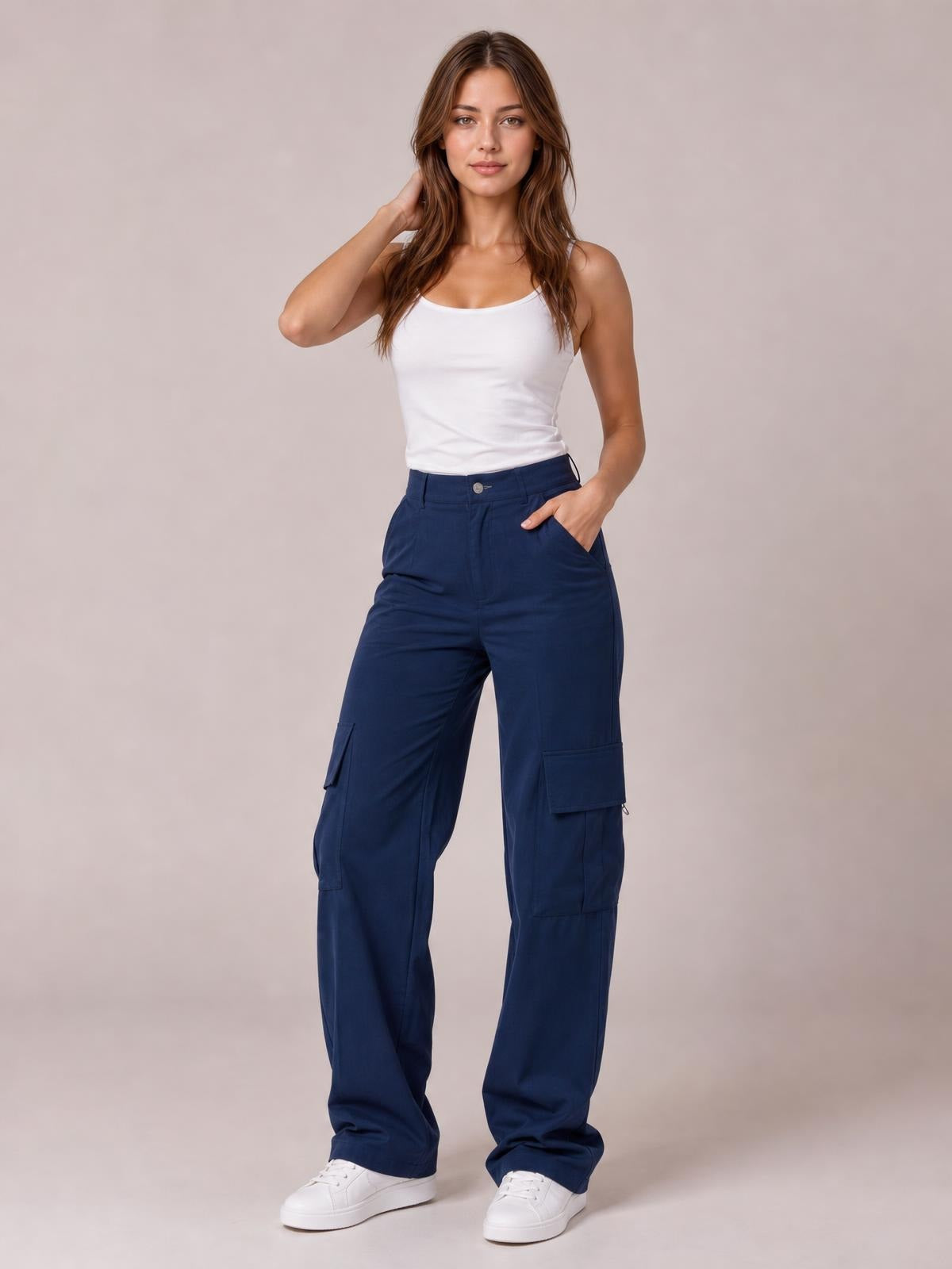 Model poses in navy high-waisted cargo pants with a relaxed wide-leg silhouette, button closure, side pockets, and large utility leg pockets.