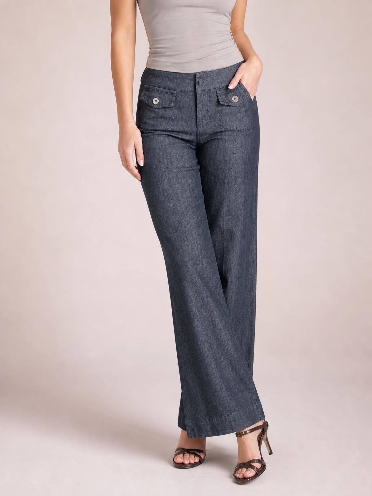 Model wearing dark-wash high-waisted wide-leg jeans with buttoned flap pockets, a front closure, and a full-length relaxed silhouette.