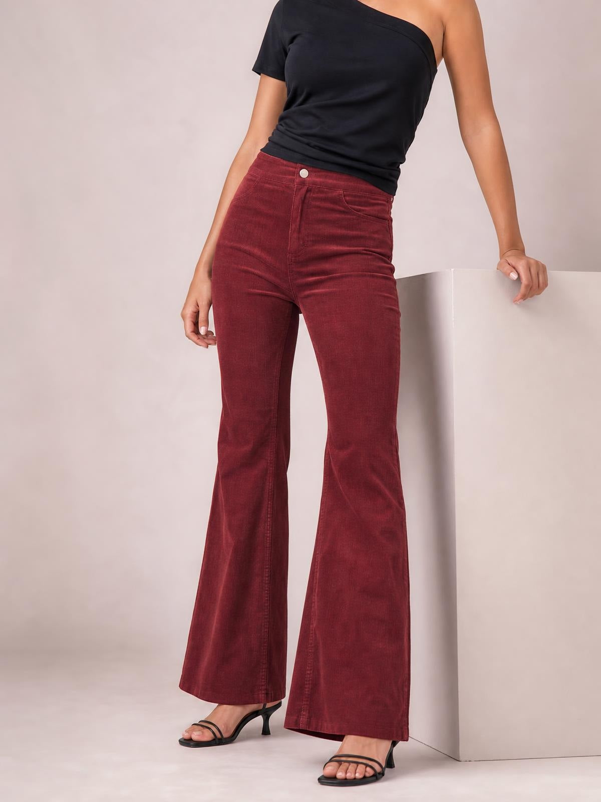 Model wearing burgundy high-waisted bootcut pants with a fitted waist, front pockets, button closure, and gently flared full-length legs.