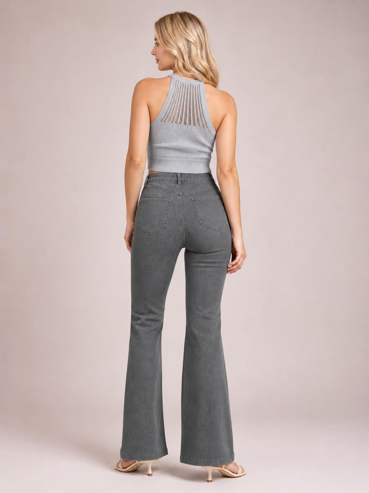 Model shown from the back wearing high-waisted gray bootcut pants with a fitted seat, belt loops, rear patch pockets, and flared hems.