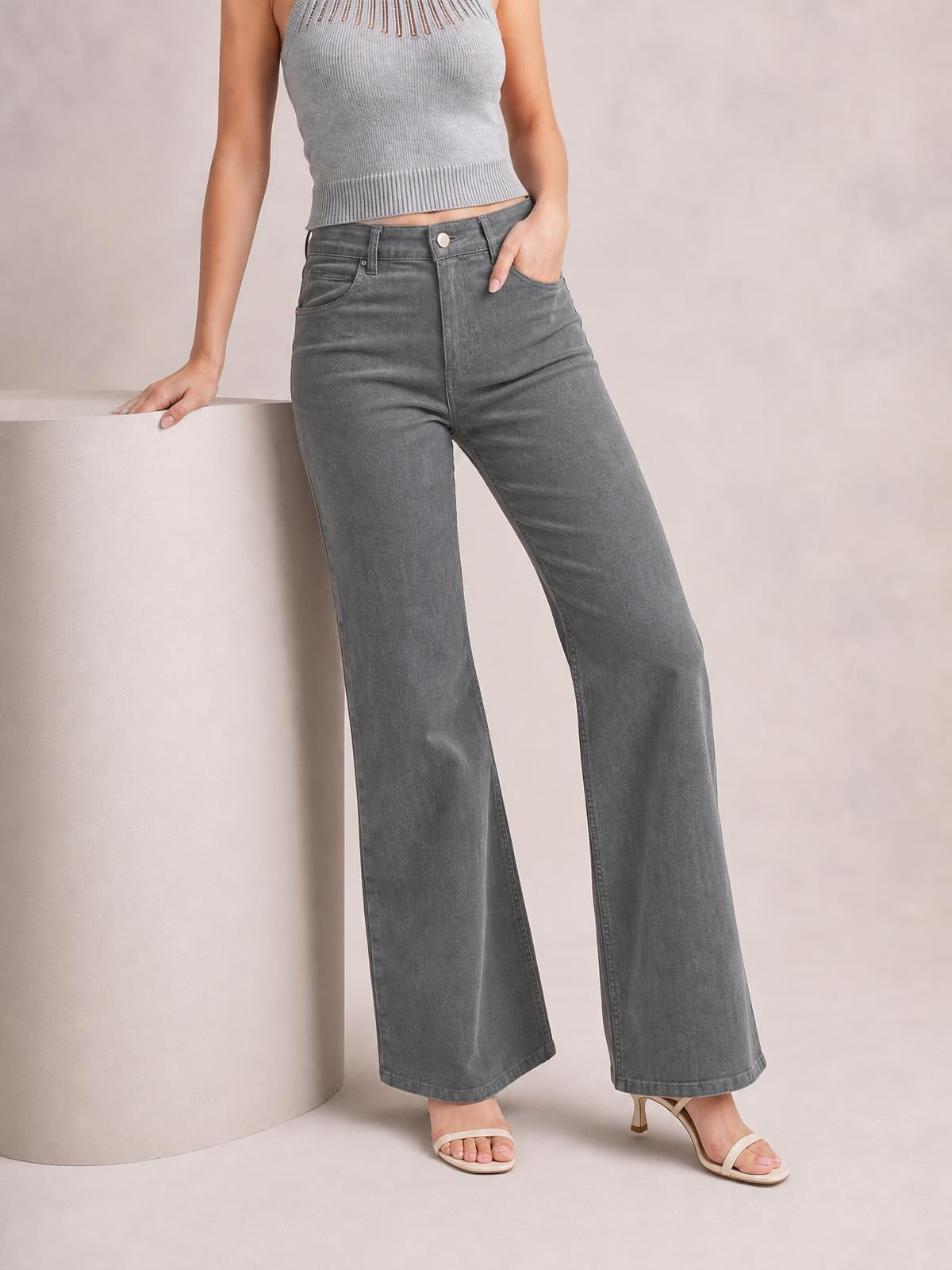 Model wearing high-waisted gray bootcut pants with a fitted waist, button closure, belt loops, front pockets, and wide flared legs.
