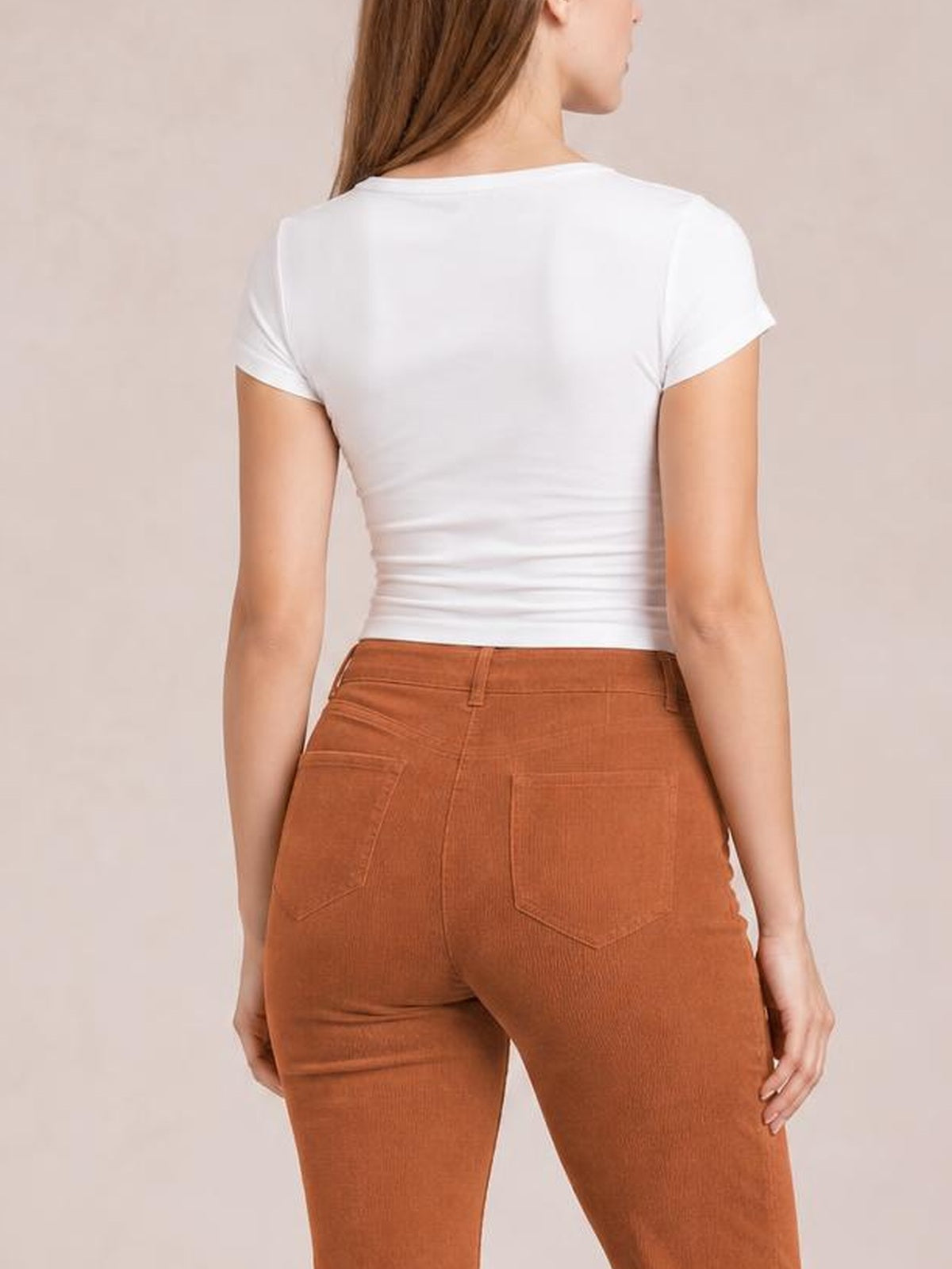 Model shown from behind wears rust-brown high-waisted bootcut pants with a fitted silhouette, belt loops, waistband, and stitched back patch pockets.