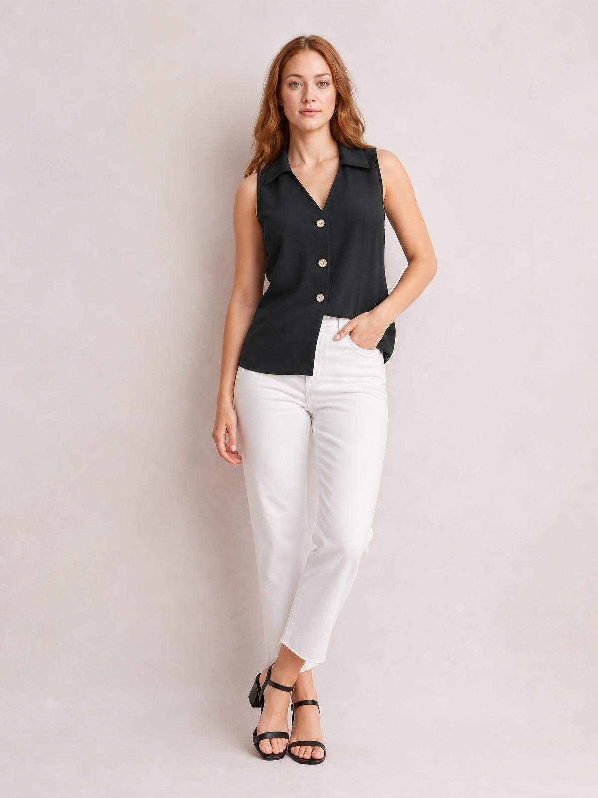 Model poses in a black Johnny collar button-up tank with a relaxed sleeveless silhouette, V-neckline, and three visible front buttons.