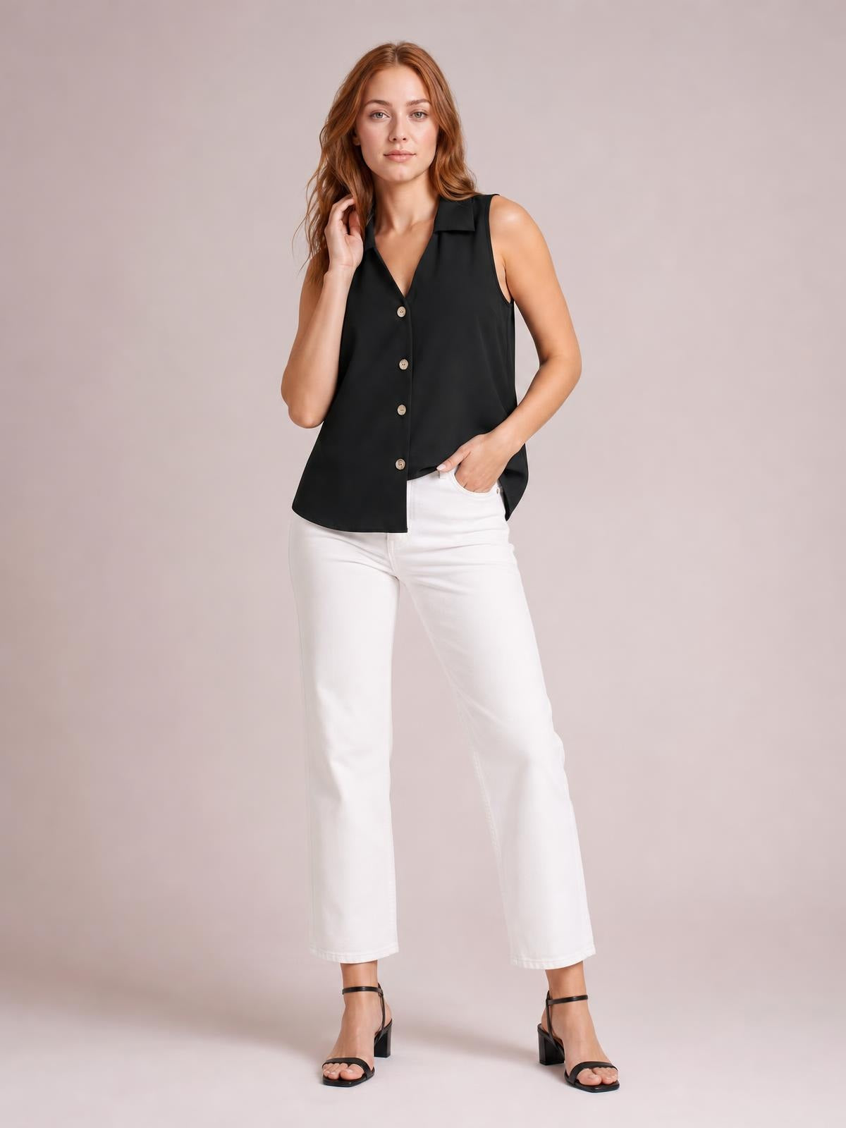 A model poses in a black Johnny collar button-up tank with a sleeveless design, front buttons, V-neckline, and relaxed straight silhouette.