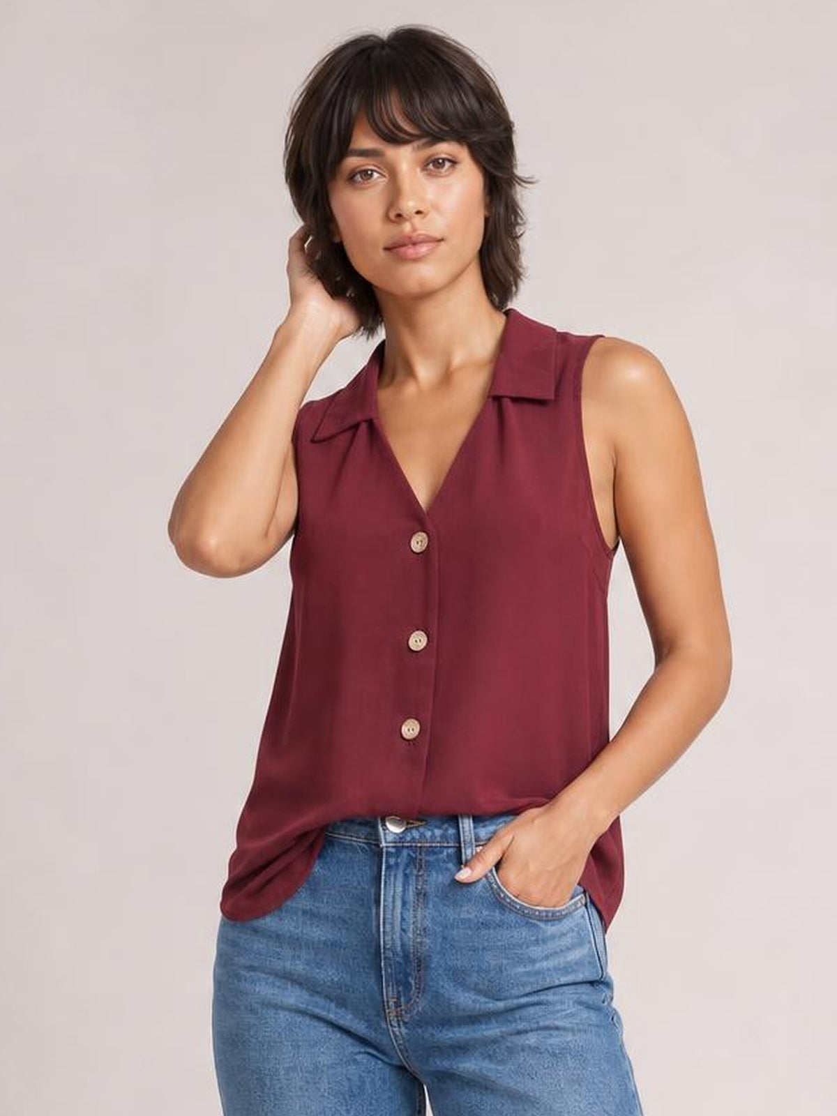 Model poses in a burgundy Johnny collar button-up tank with a relaxed straight silhouette, sleeveless cut, V-neckline, and visible front buttons.