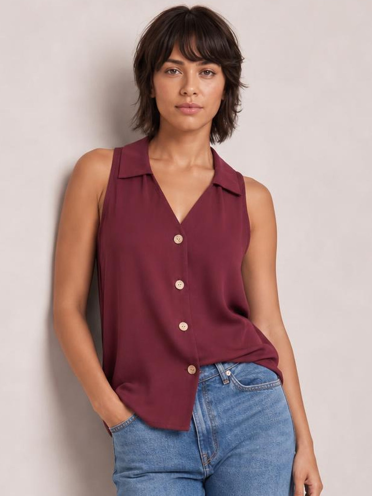 Model wearing a burgundy Johnny collar button-up tank with a sleeveless silhouette, pointed collar, V-neckline, and visible front buttons.