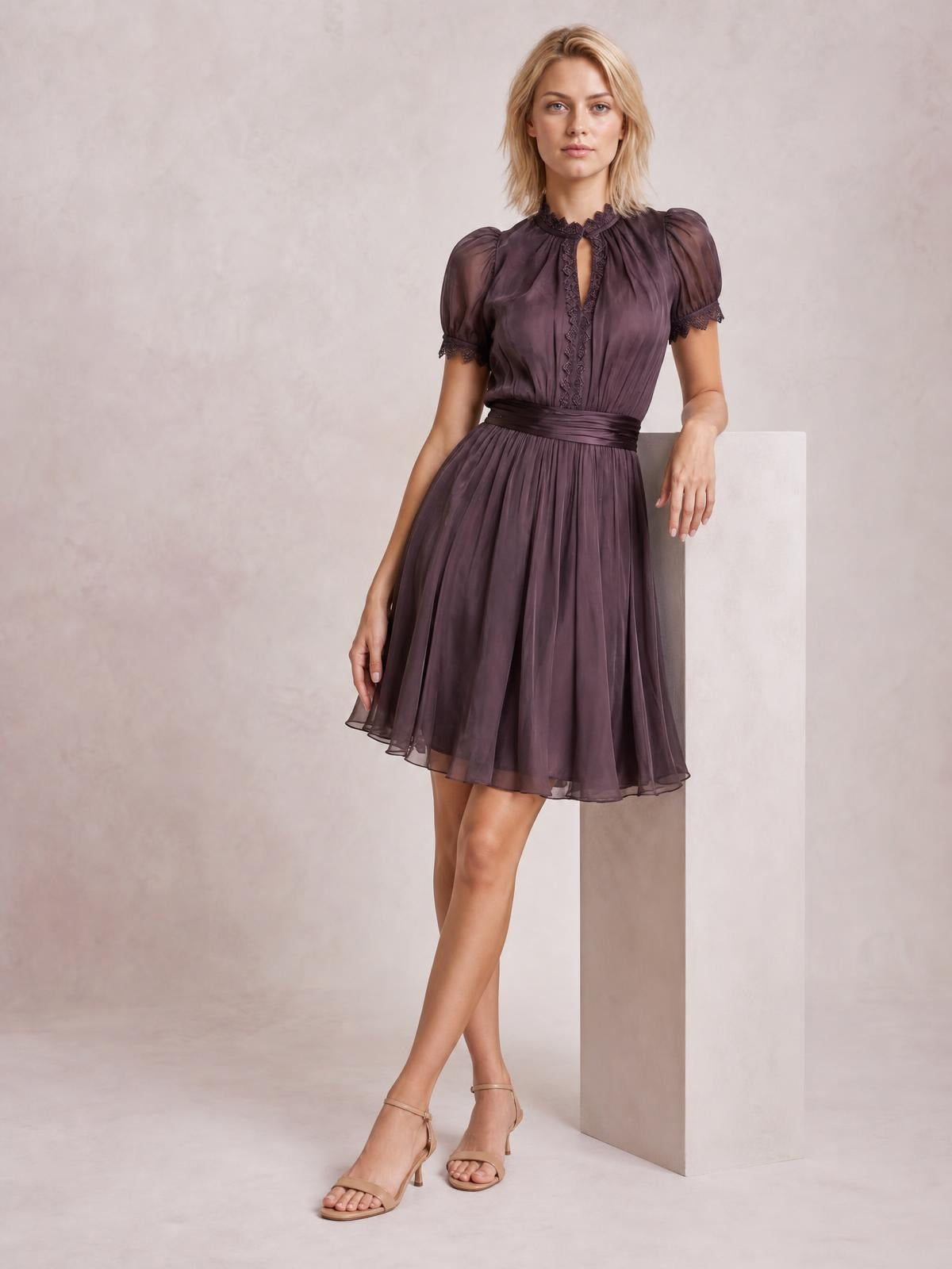 Model poses in a plum lace-trim A-line dress with puff sleeves, a gathered waist, keyhole neckline, and softly pleated knee-length skirt.