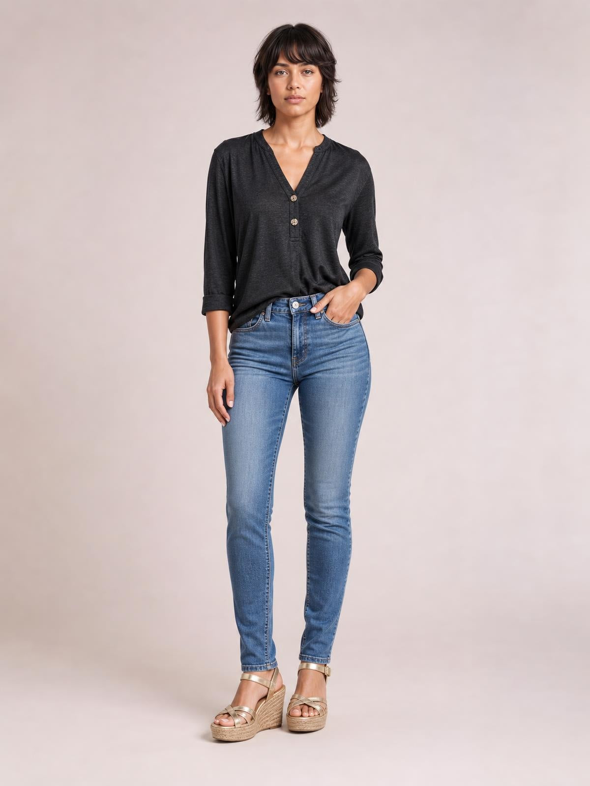 Model wears a dark charcoal notched long sleeve T-shirt with a V-neckline, two-button placket, relaxed silhouette, and rolled cuffs.