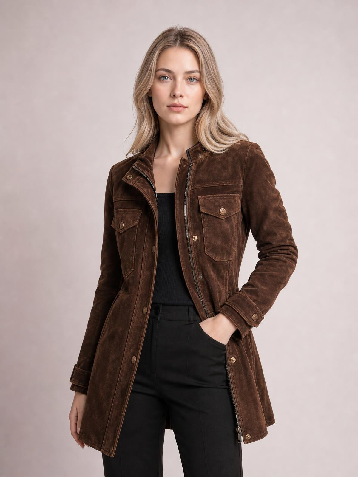 Model poses in a brown long-sleeve jacket with a straight long silhouette, zip front, snap details, and multiple flap pockets.