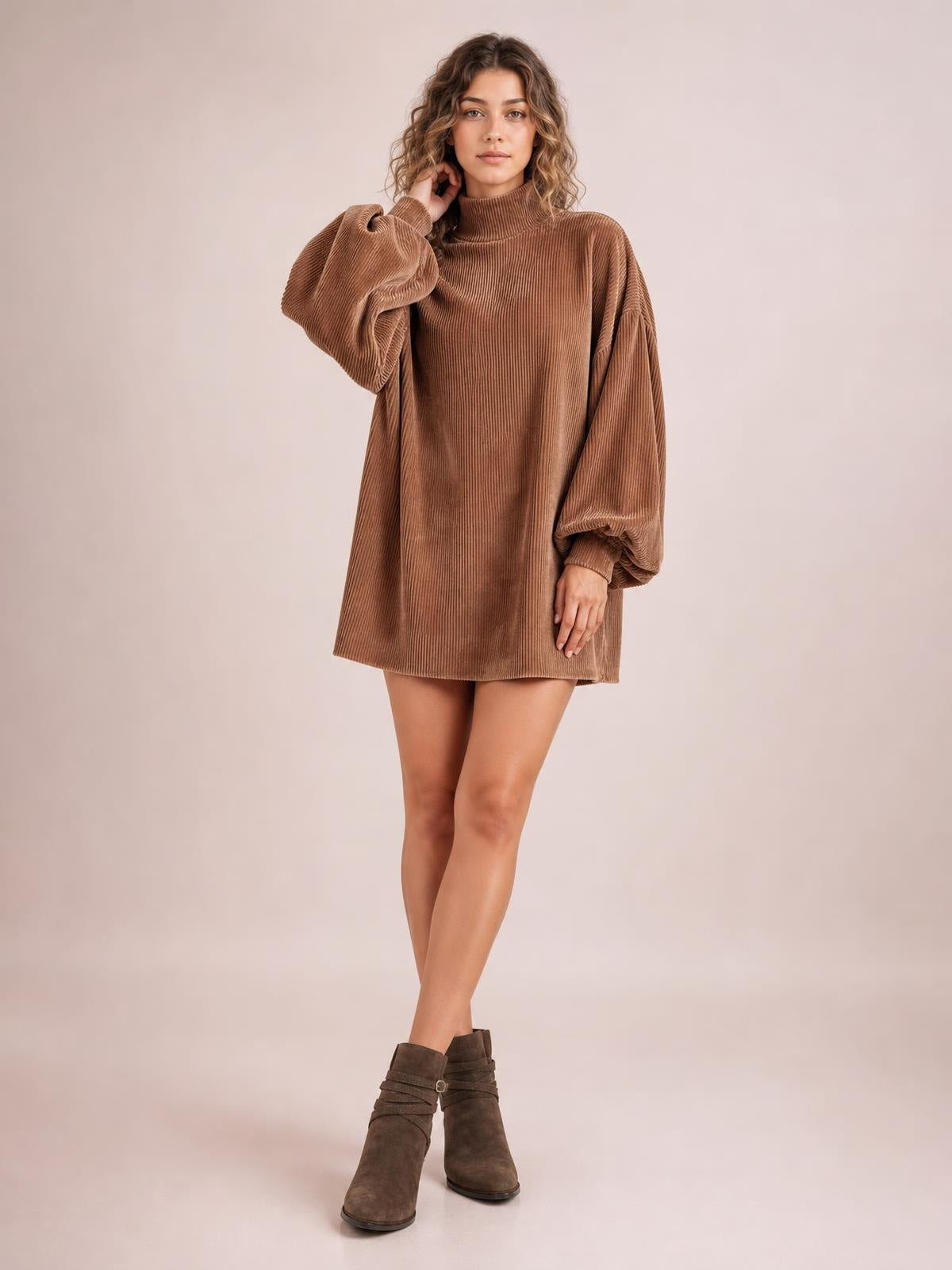 Model poses with one hand at her neck in a brown ribbed mock neck mini dress featuring voluminous lantern sleeves and a relaxed straight silhouette.