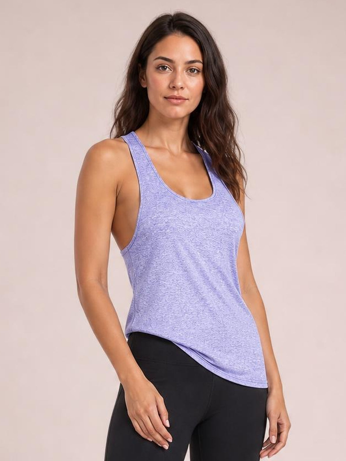 Model wears a lavender scoop neck active tank with wide straps, a relaxed silhouette, and curved hem over black leggings.