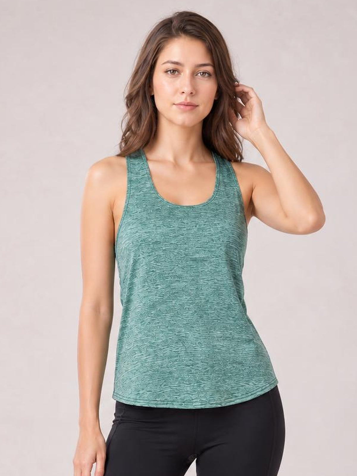Model poses in a teal scoop neck wide strap active tank with a relaxed, slightly fitted silhouette and textured construction.